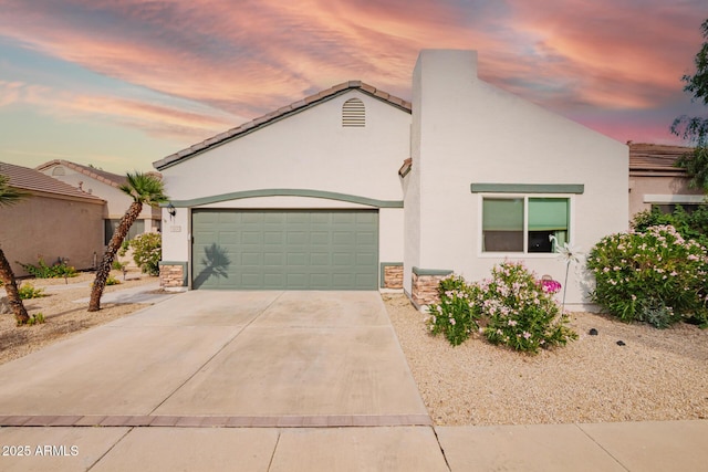 7031 S 32nd Pl, Phoenix, AZ 85042 - view of front of property with stucco siding, concrete driveway, stone siding, and an attached garage