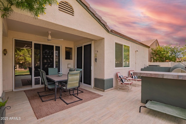 7031 S 32nd Pl, Phoenix, AZ 85042 - patio terrace at dusk featuring a ceiling fan, a patio, and outdoor dining space