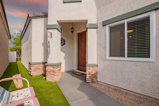 7031 S 32nd Pl, Phoenix, AZ 85042 - exterior entry at dusk with stucco siding and stone siding