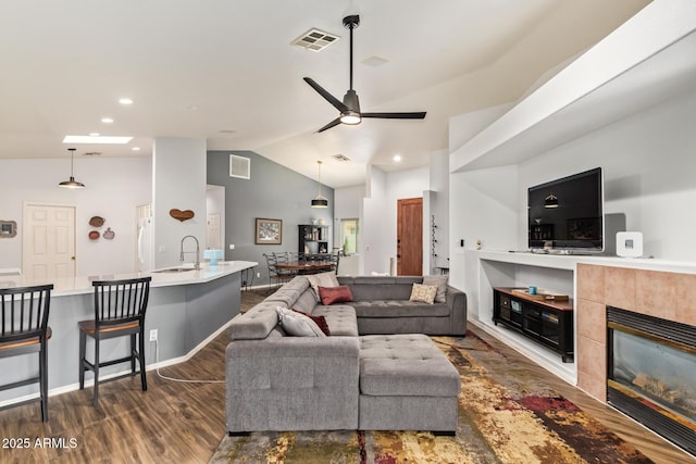 7031 S 32nd Pl, Phoenix, AZ 85042 - living area with dark wood-style floors, a ceiling fan, a tile fireplace, recessed lighting, and high vaulted ceiling