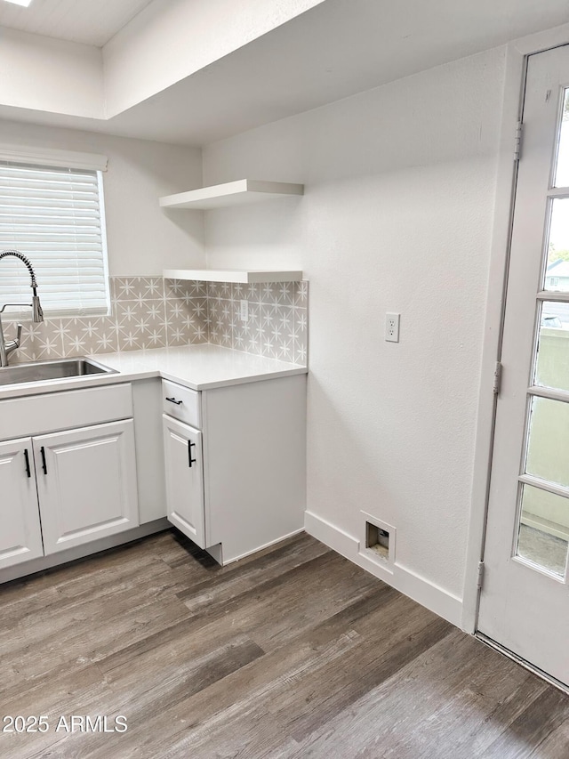 interior space with cabinet space, visible vents, baseboards, wood finished floors, and a sink