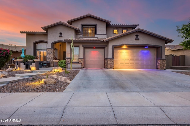 2728 W Adventure Dr, Anthem, AZ 85086 - mediterranean / spanish home featuring stone siding, stucco siding, driveway, a tile roof, and an attached garage
