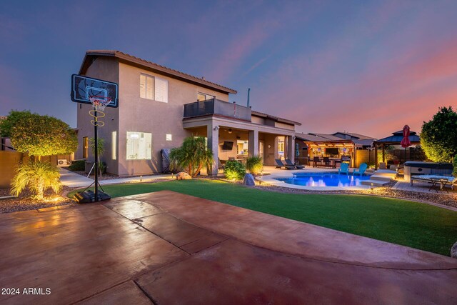2728 W Adventure Dr, Anthem, AZ 85086 - back of property at dusk with a balcony, a gazebo, a patio area, stucco siding, and a hot tub