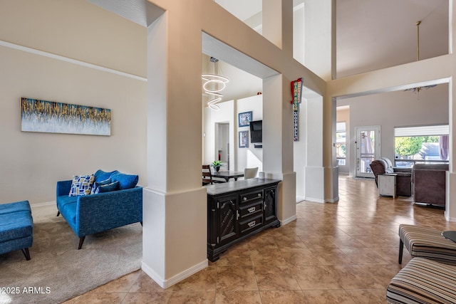 2728 W Adventure Dr, Anthem, AZ 85086 - hall featuring a towering ceiling, a chandelier, light carpet, and light tile patterned floors