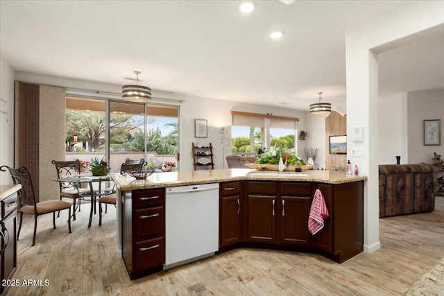 kitchen with dishwasher, sink, and light hardwood / wood-style floors