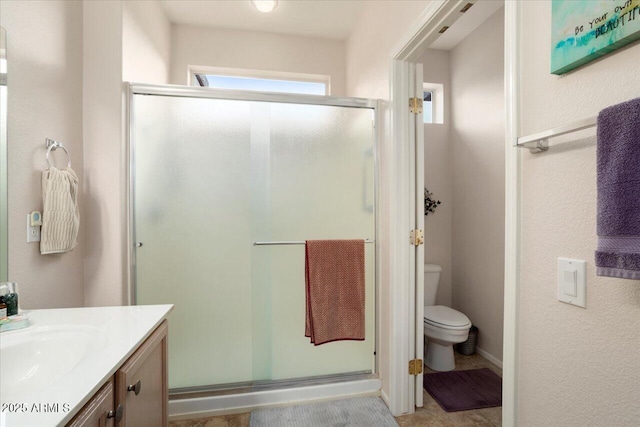 bathroom with vanity, a shower with shower door, and toilet