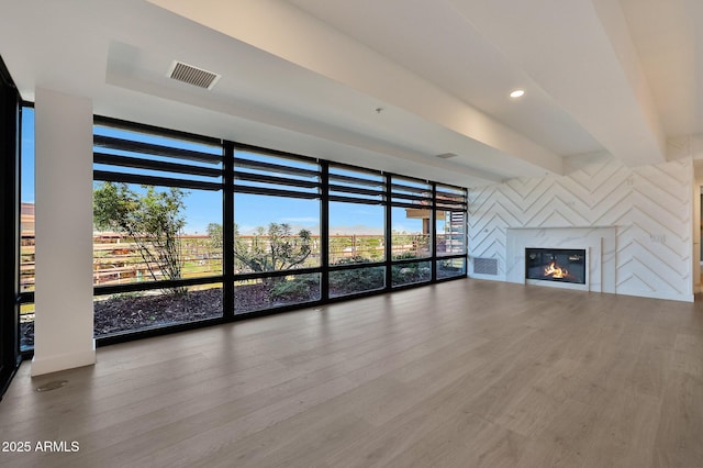 unfurnished living room with a fireplace, visible vents, wood finished floors, and recessed lighting