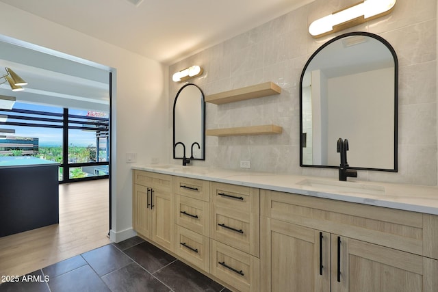 bathroom featuring double vanity, tile patterned flooring, tasteful backsplash, and a sink