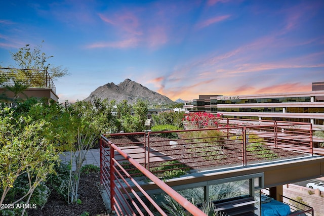 balcony at dusk featuring a mountain view