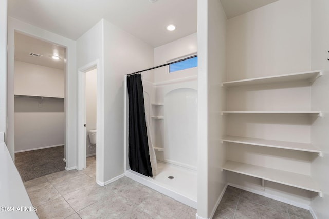 bathroom with tile patterned flooring, toilet, and a shower with shower curtain