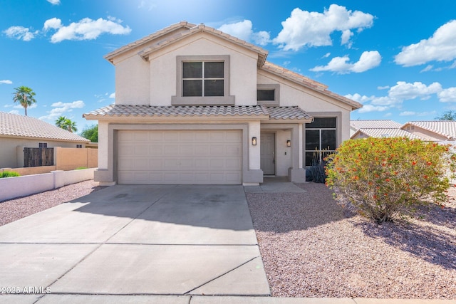 mediterranean / spanish-style house featuring stucco siding, a tile roof, driveway, an attached garage, and fence