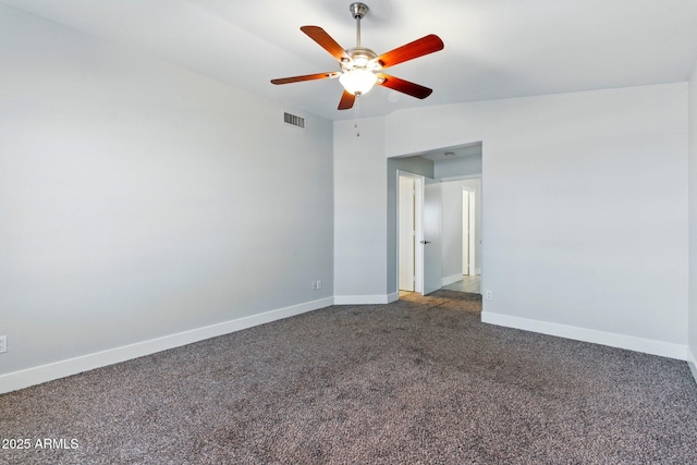 spare room with a ceiling fan, dark carpet, and baseboards
