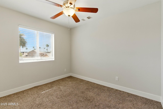carpeted spare room with ceiling fan and baseboards