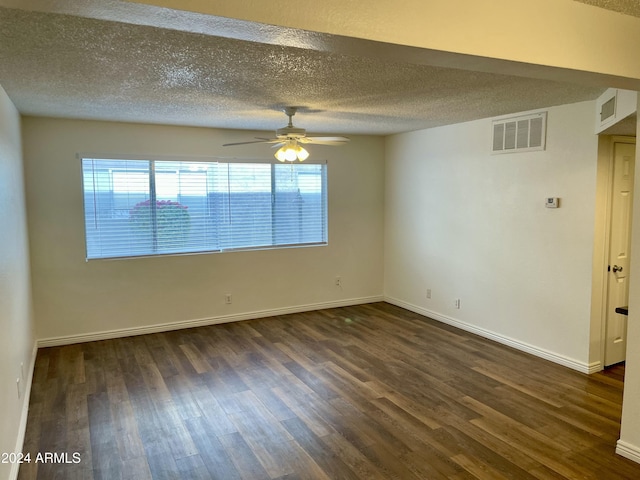 spare room featuring a textured ceiling, dark hardwood / wood-style floors, a wealth of natural light, and ceiling fan