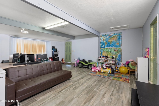 game room with light hardwood / wood-style floors and a textured ceiling