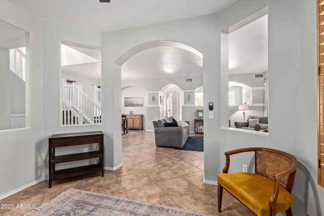 13420 W Berridge Ln, Litchfield Park, AZ 85340 - hall with arched walkways, tile patterned flooring, baseboards, and stairway