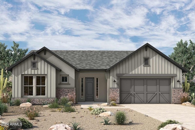 modern farmhouse featuring an attached garage, stone siding, decorative driveway, and board and batten siding