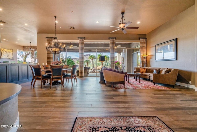 living room featuring hardwood / wood-style flooring and ceiling fan with notable chandelier