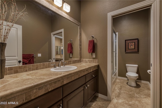 full bathroom with shower / bath combination with glass door, vanity, and toilet