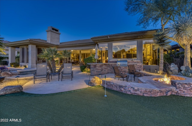 view of patio / terrace with a fire pit, area for grilling, and exterior kitchen