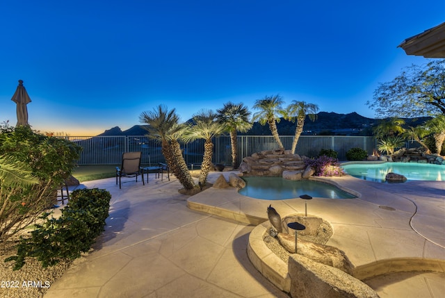 pool at dusk featuring a patio