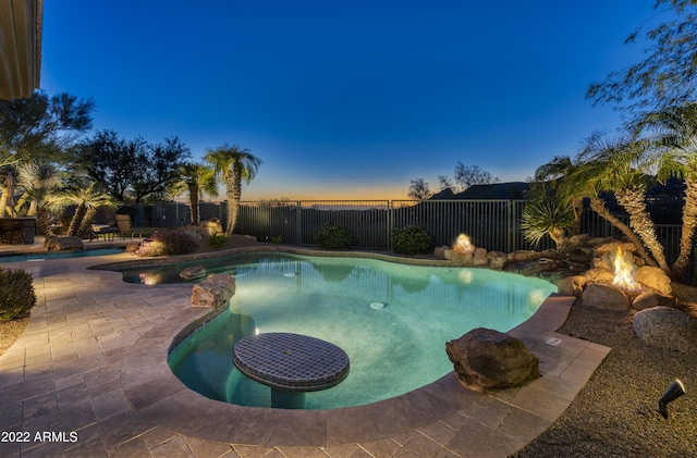 pool at dusk featuring a patio area