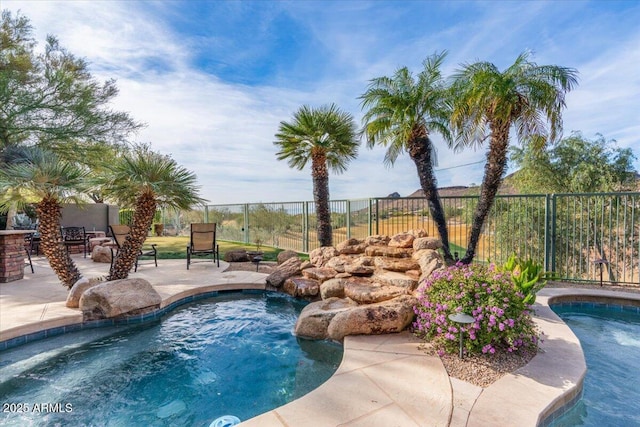 view of swimming pool featuring pool water feature and a hot tub