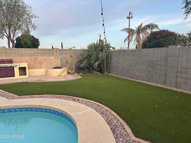 view of swimming pool with a fenced backyard, a fenced in pool, and a yard