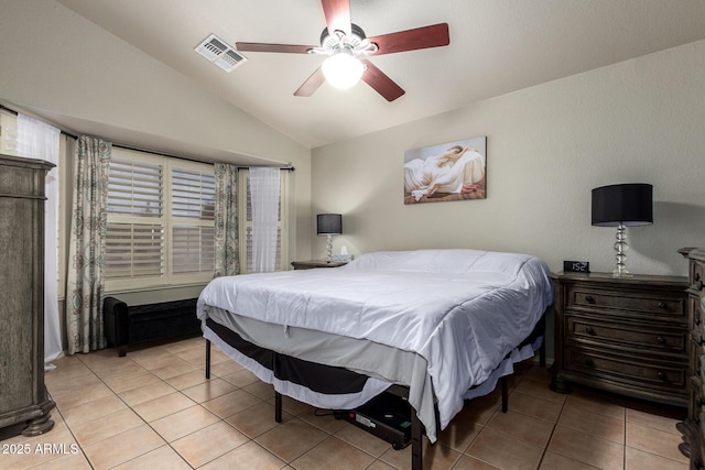 bedroom with vaulted ceiling, light tile patterned floors, visible vents, and a ceiling fan