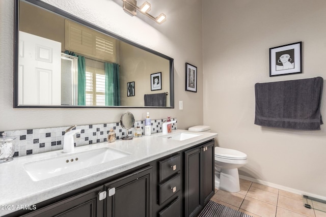 bathroom featuring double vanity, tile patterned flooring, a sink, and toilet