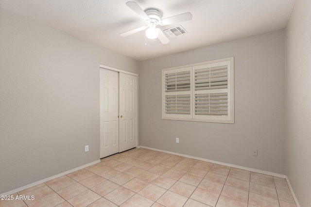 unfurnished bedroom with a closet, visible vents, ceiling fan, and baseboards