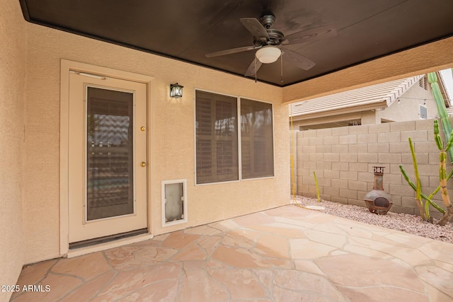 view of patio featuring ceiling fan and fence