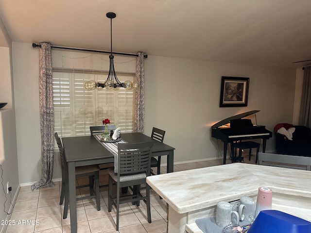 dining space with light tile patterned floors, baseboards, and a notable chandelier