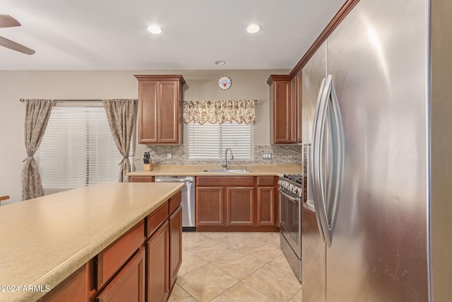 kitchen with sink, ceiling fan, light tile patterned floors, tasteful backsplash, and stainless steel appliances