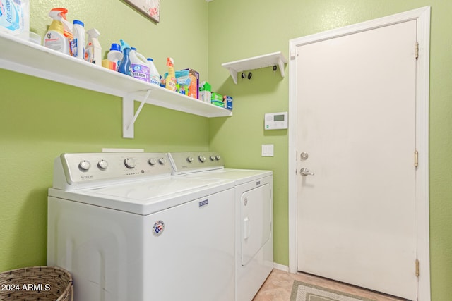 clothes washing area featuring light tile patterned flooring and washing machine and dryer