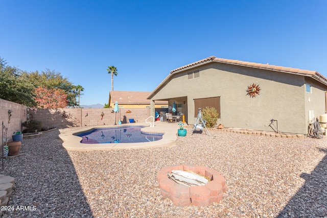 exterior space with a fenced in pool, a fire pit, and a patio area