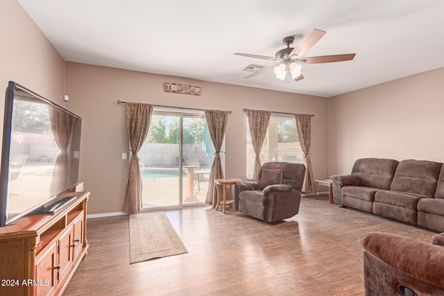 living room with plenty of natural light, ceiling fan, and dark hardwood / wood-style flooring