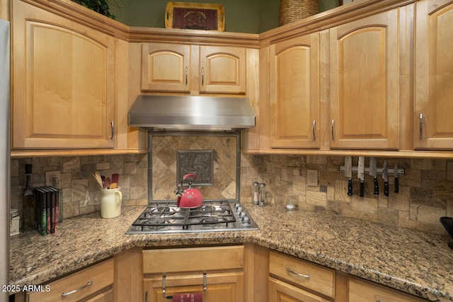 kitchen with stainless steel gas stovetop, stone countertops, backsplash, and range hood