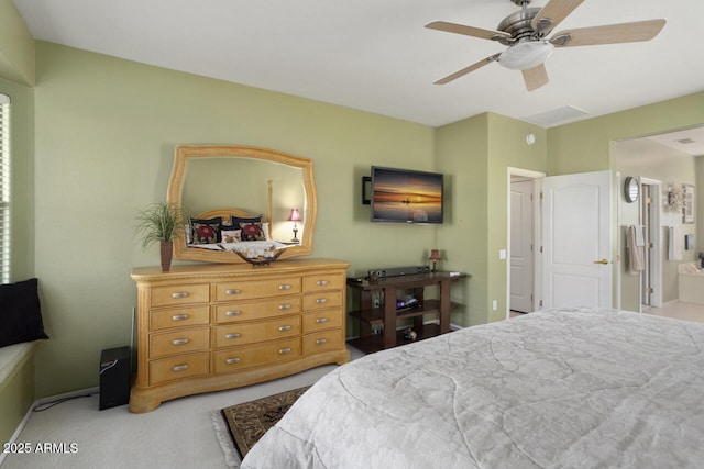 bedroom with light colored carpet, ceiling fan, and ensuite bathroom