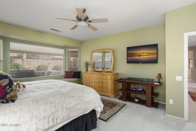 carpeted bedroom featuring ceiling fan and multiple windows