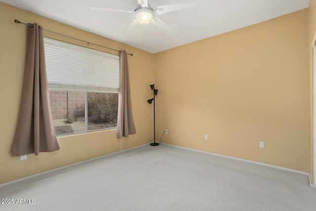 carpeted spare room featuring ceiling fan