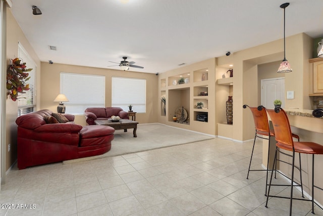 living room featuring ceiling fan, built in features, and light tile patterned floors