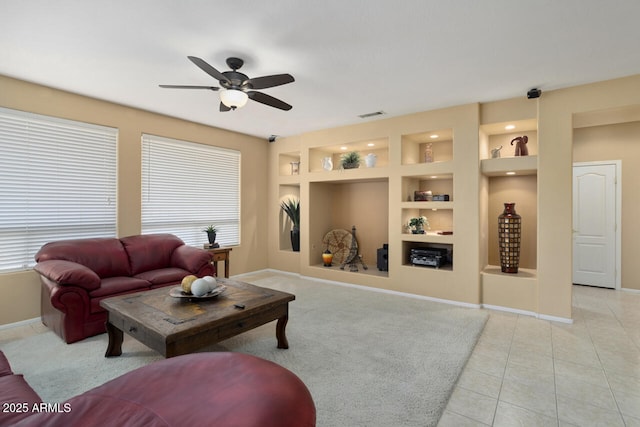 tiled living room featuring built in shelves and ceiling fan