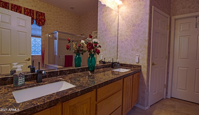 bathroom featuring vanity, a shower with door, and tile patterned flooring