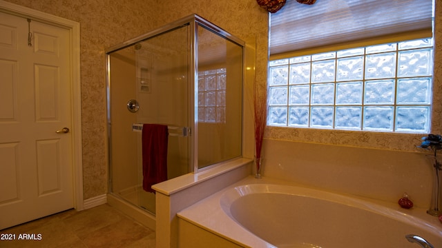 bathroom with tile patterned floors, independent shower and bath, and a wealth of natural light