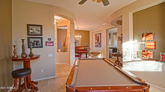 rec room with pool table and ceiling fan with notable chandelier