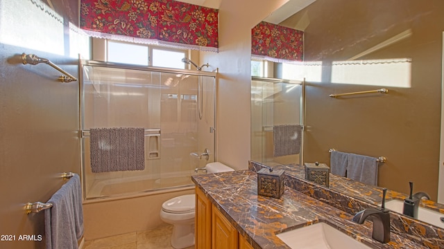 full bathroom featuring vanity, toilet, tile patterned flooring, and bath / shower combo with glass door