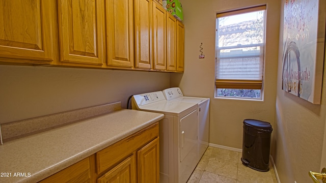 washroom featuring washing machine and dryer and cabinets