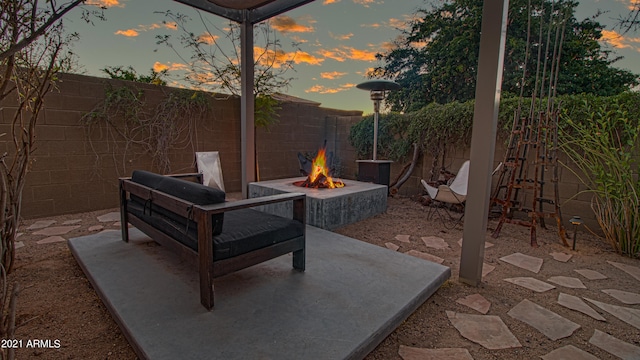 patio terrace at dusk featuring a fire pit