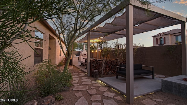 patio terrace at dusk featuring a pergola